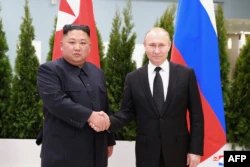 Presiden Rusia Vladimir Putin (kanan) dan pemimpin Korea Utara Kim Jong Un berjabat tangan. (Foto: AFP)
