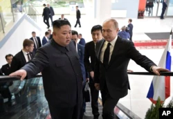 Presiden Rusia Vladimir Putin, kanan, dan pemimpin Korea Utara Kim Jong Un naik lift menuju pembicaraan di Vladivostok, Rusia, Kamis, 25 April 2019. (Foto: via AP)