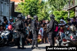 Anggota polisi anti-terorisme Densus 88 mengepung sebuah jalan ketika mereka menggeledah sebuah rumah di Surabaya, Jawa Timur, pada 19 Juni 2017, menyusul penangkapan seorang pria yang diduga terkait dengan kelompok Negara Islam (ISIS). (Foto: AFP)
