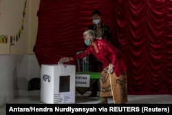 Seorang lansia memberikan suara saat pilkada di tengah pandemi COVID-19 di Sleman, Yogyakarta, 9 Desember 2020. (Foto: Antara/Hendra Nurdiyansyah via REUTERS)
