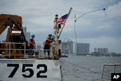 Seorang awak kapal US Coast Guard Cutter Stratton (WMSL 752) melempar ujung tali saat mereka berlabuh di Manila, Filipina pada Kamis, 1 Juni 2023. (Foto: AP)