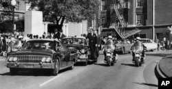 FILE - Dilihat dari kaca depan mobil convertible, Presiden John F. Kennedy memegang kepalanya beberapa detik setelah tertembak, sementara ibu negara Jacqueline Kennedy memegang lengannya saat mobilnya melewati Elm Street, Dallas, 22 November 1963. (AP/James W. "Ike" Altgens)