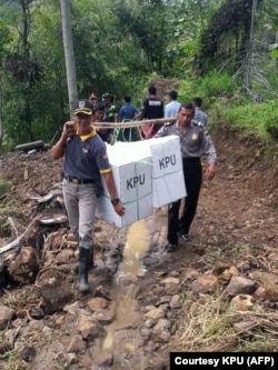 Pekerja mengantarkan kotak suara ke desa-desa terpencil di Yalimo, Provinsi Papua pada 2019. (Foto: Courtesy/Komisi Pemilihan Umum/AFP)