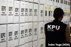 Pengawas KPU Kota Depok berjalan melewati kotak suara Pemilu 2024 di Gudang KPU Kota Depok pada Rabu (10/1) di Cibinong, Jawa Barat. (VOA/Indra Yoga)