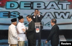Kandidat Capres-Cawapres Prabowo Subianto-Hatta Rajasa menyalami Joko Widodo-Jusuf Kalla sebelum acara debat di Jakarta, Senin (9/6).